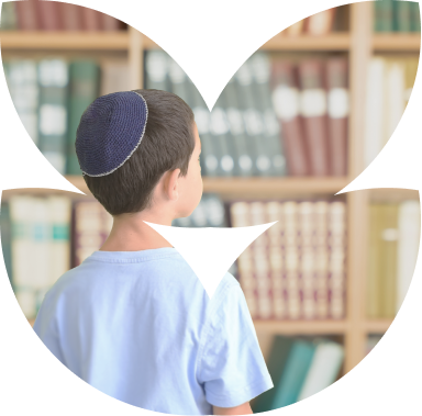 ילד עם כיפה עומד מול ספרייה